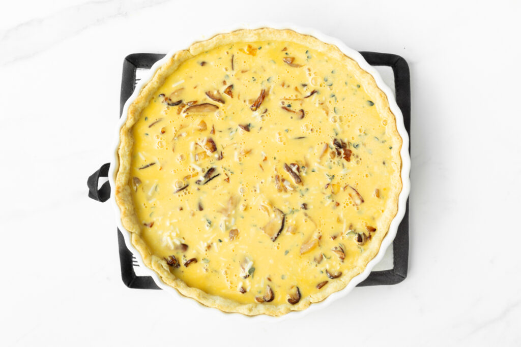 Process shot #4: Egg mixture now added on top of the mushrooms and onions in the prepared quiche crust.