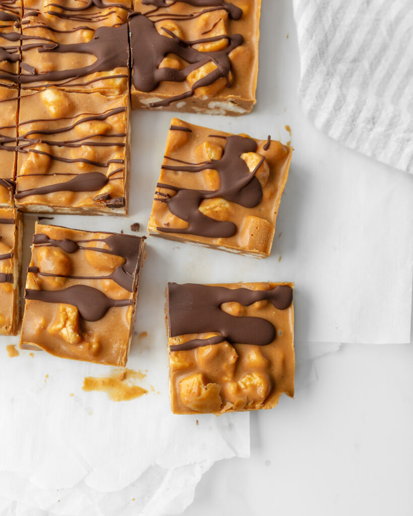 Butterscotch Marshmallow Bars drizzled with chocolate and cut on parchment paper.