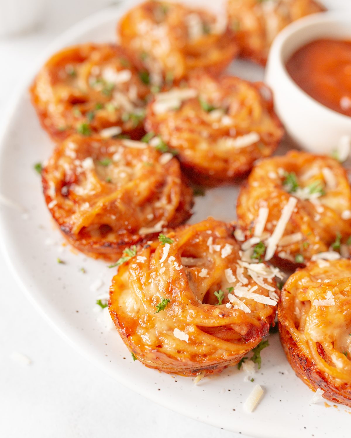 Cheesy Baked Spaghetti Bites garnished with fresh parsley.