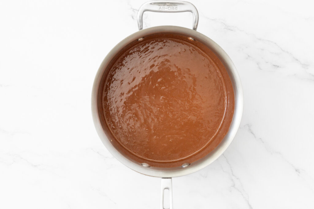 Process shot #1: A small saucepan with melted chocolate, peanut butter and coconut oil in it.