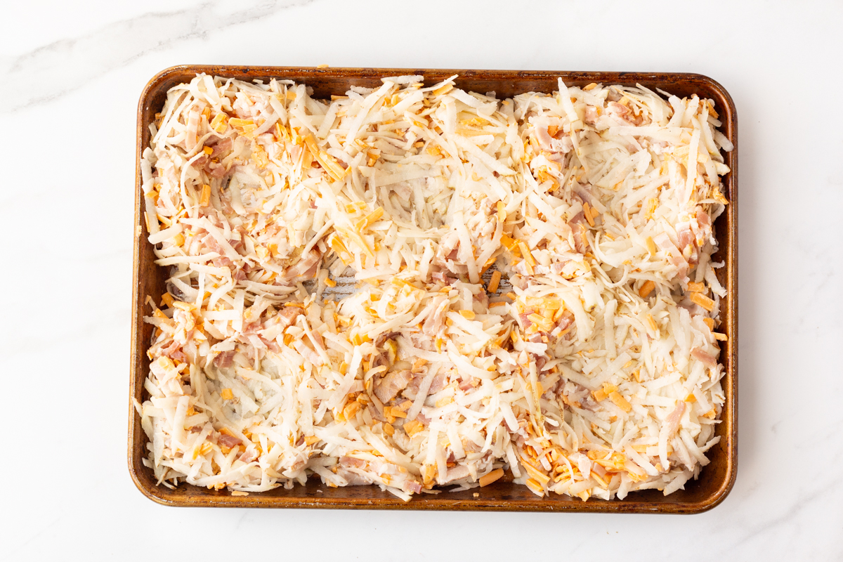 Process shot #4: Shredded potato, cheese and bacon mixture formed into 6 nest-shapes on a sheet pan.