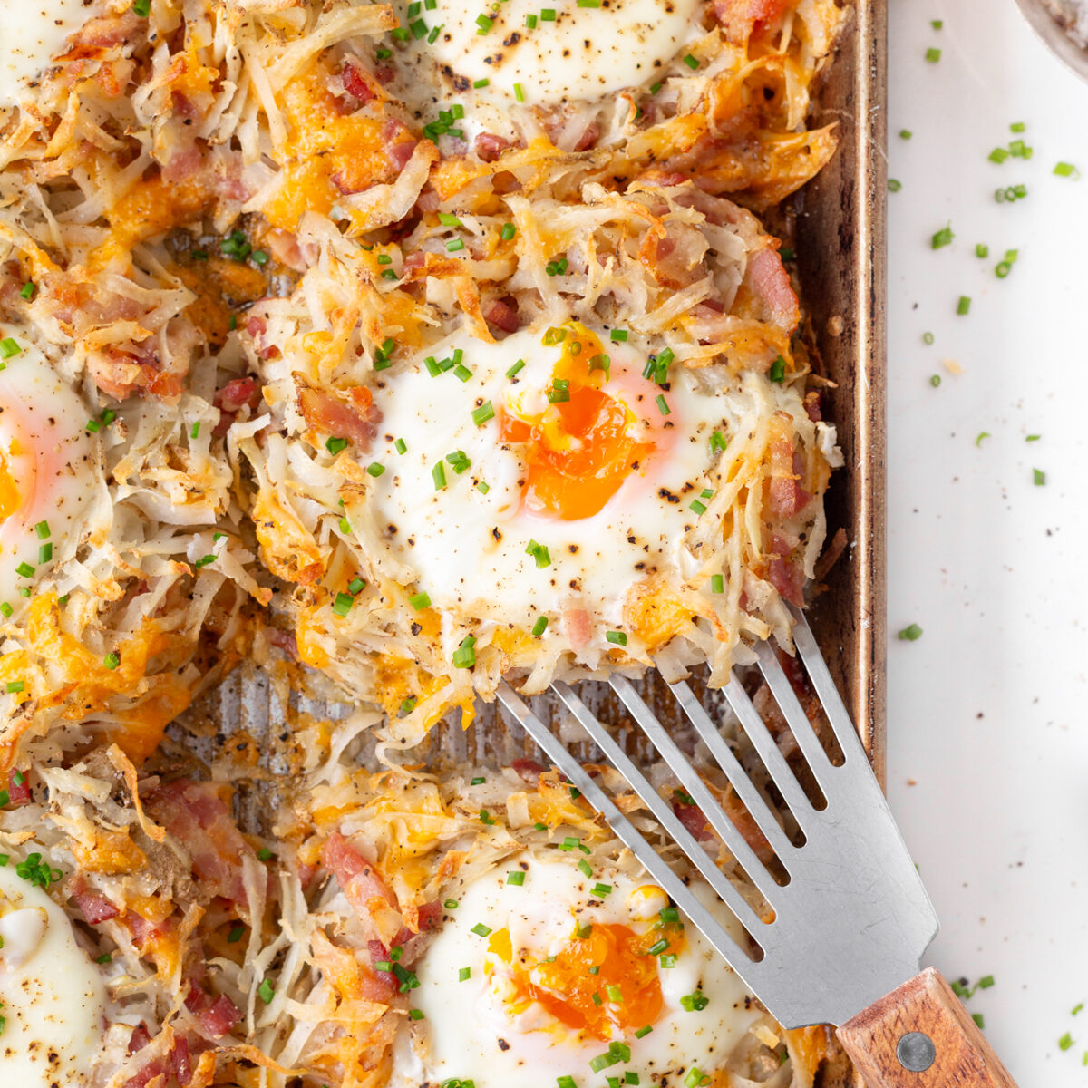 Sheet Pan Breakfast Egg Nests baked on a pan and garnished with chives.