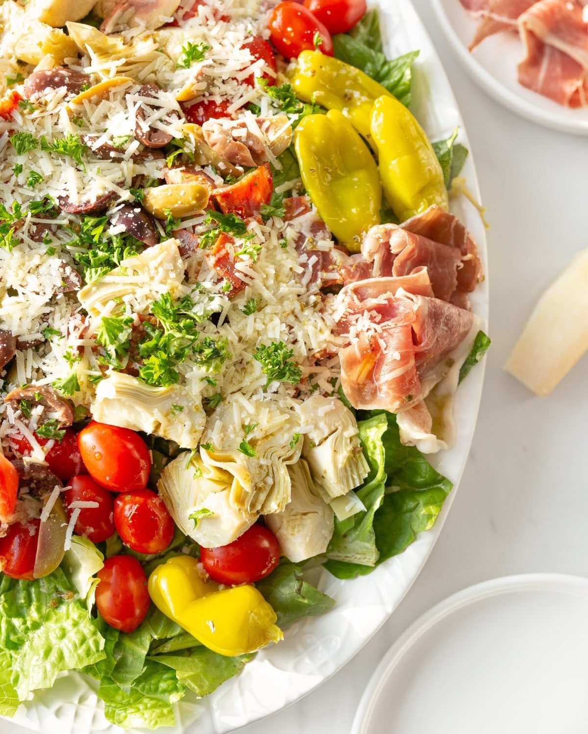 Antipasto Salad with Italian Vinaigrette plated and garnished with parmigiana cheese.