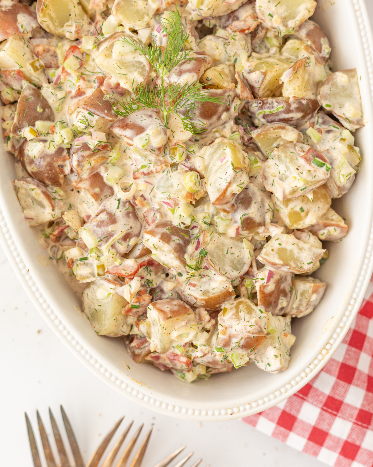 Summer Potato Salad served in an oval dish and garnished with fresh dill.