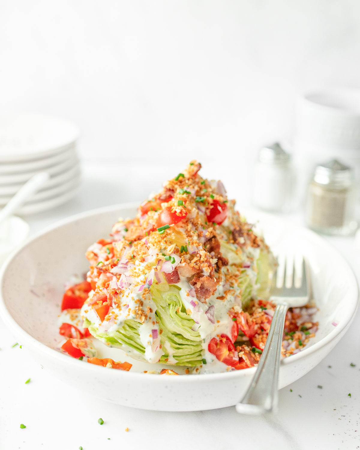 Wedge Salad plated and topped with toasted breadcrumbs and fresh chives.