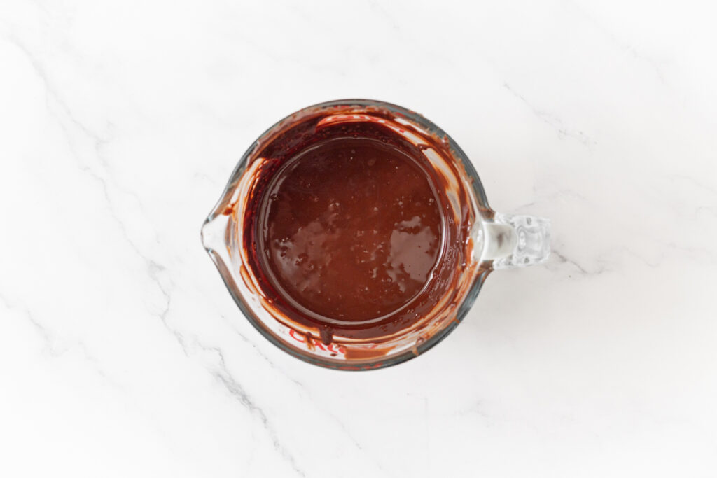Process shot #5: Chocolate and coconut oil melted in a glass measuring cup.