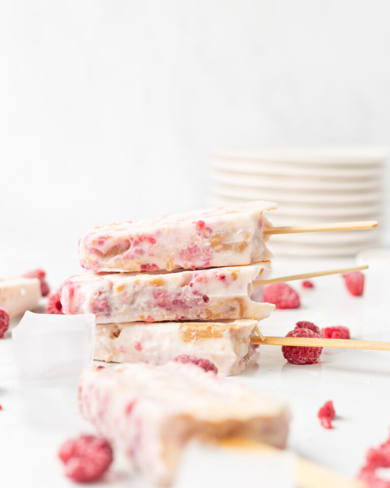 Three Peanut Butter and Jam Frozen Yogurt Bars stacked on top of each other on a marble slab.