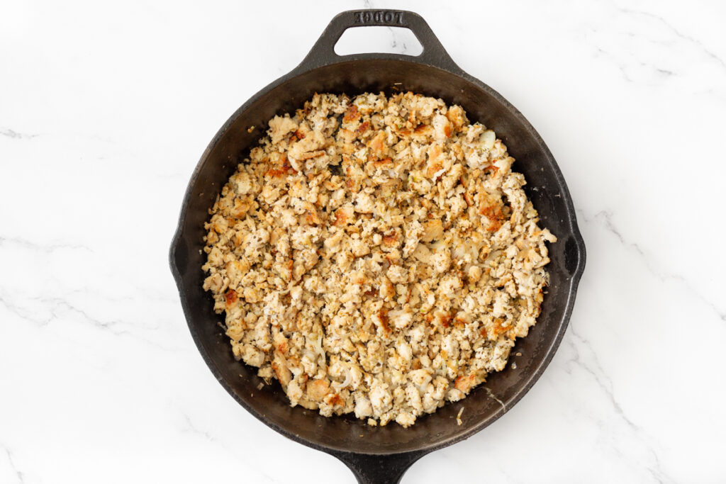 Process shot #1: Ground chicken, shallots and minced garlic cooked in a cast iron pan.