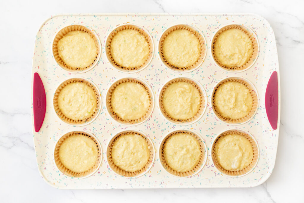 Process shot #4: grain free cupcake batter scooped into prepared muffin liners. 