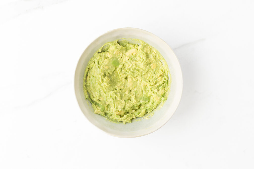 Process shot #2: Mashed avocado in a small bowl.