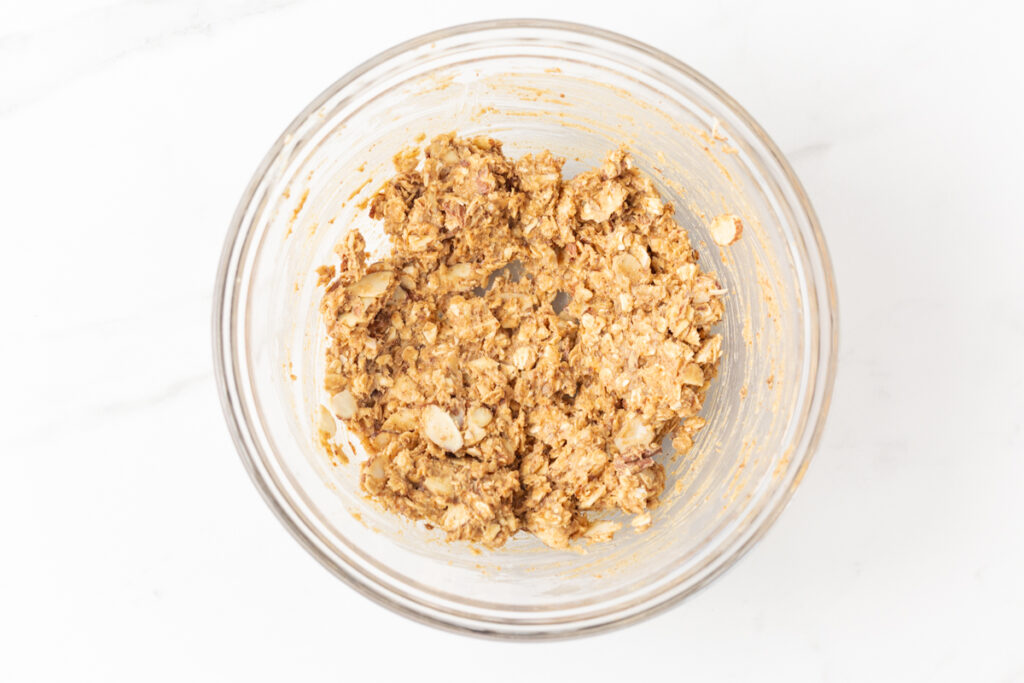 Process shot #3: All ingredients for the oat crumble topping mixed together in a glass mixing bowl.