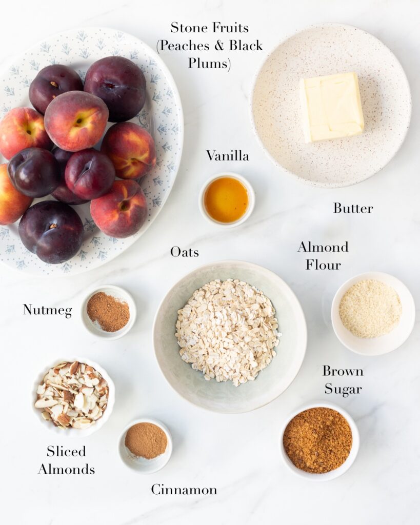 Ingredients for baked stone fruits with oats portioned out on a marble slab.