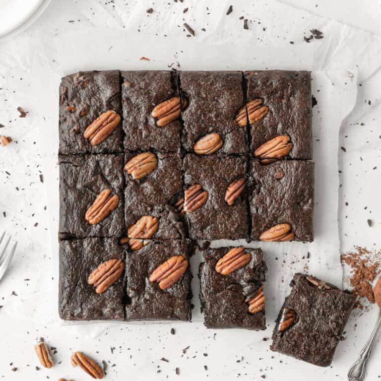 Triple Chocolate Collagen Brownies cut into squares on parchment paper.