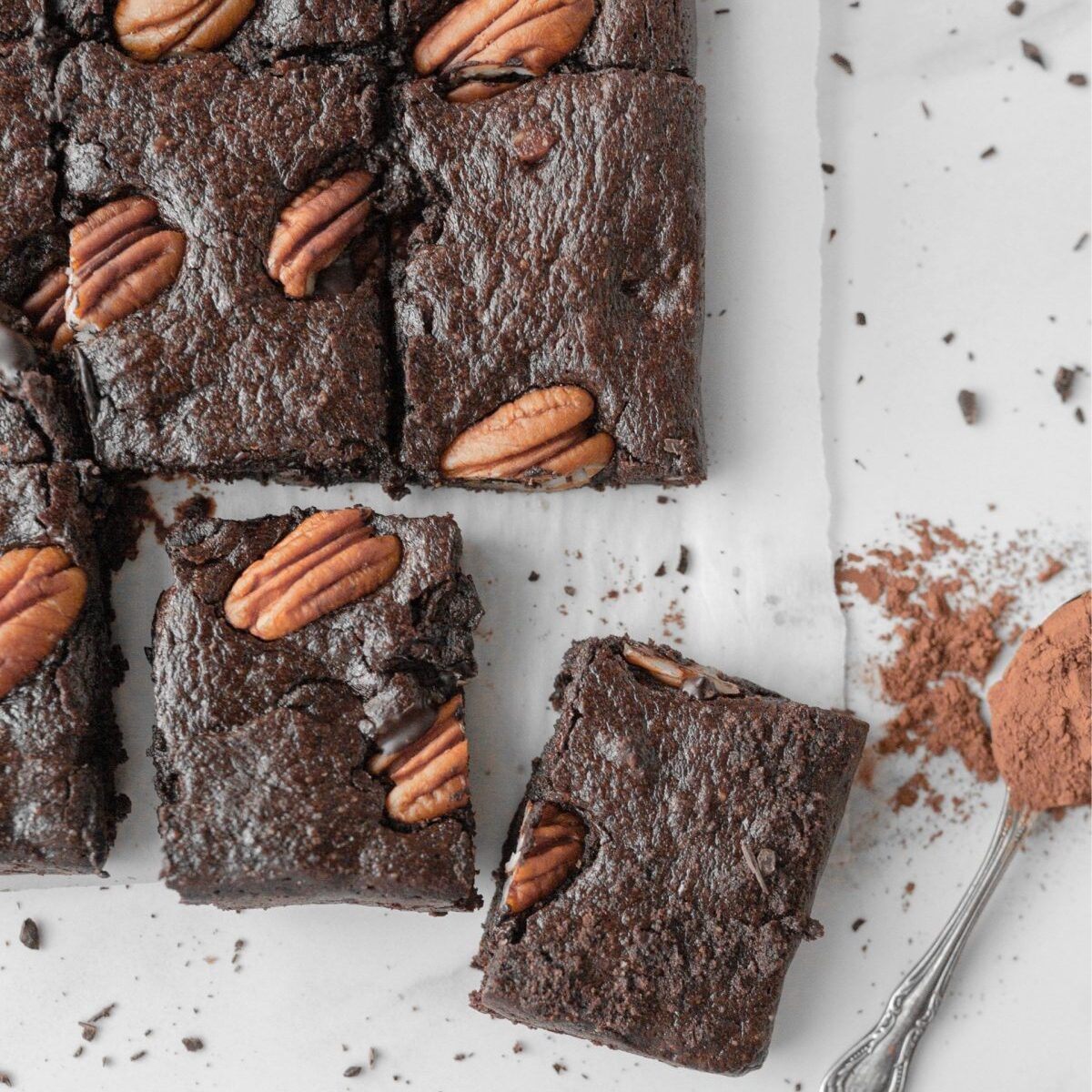 Triple Chocolate Pecan Collagen Brownies cut on parchment.