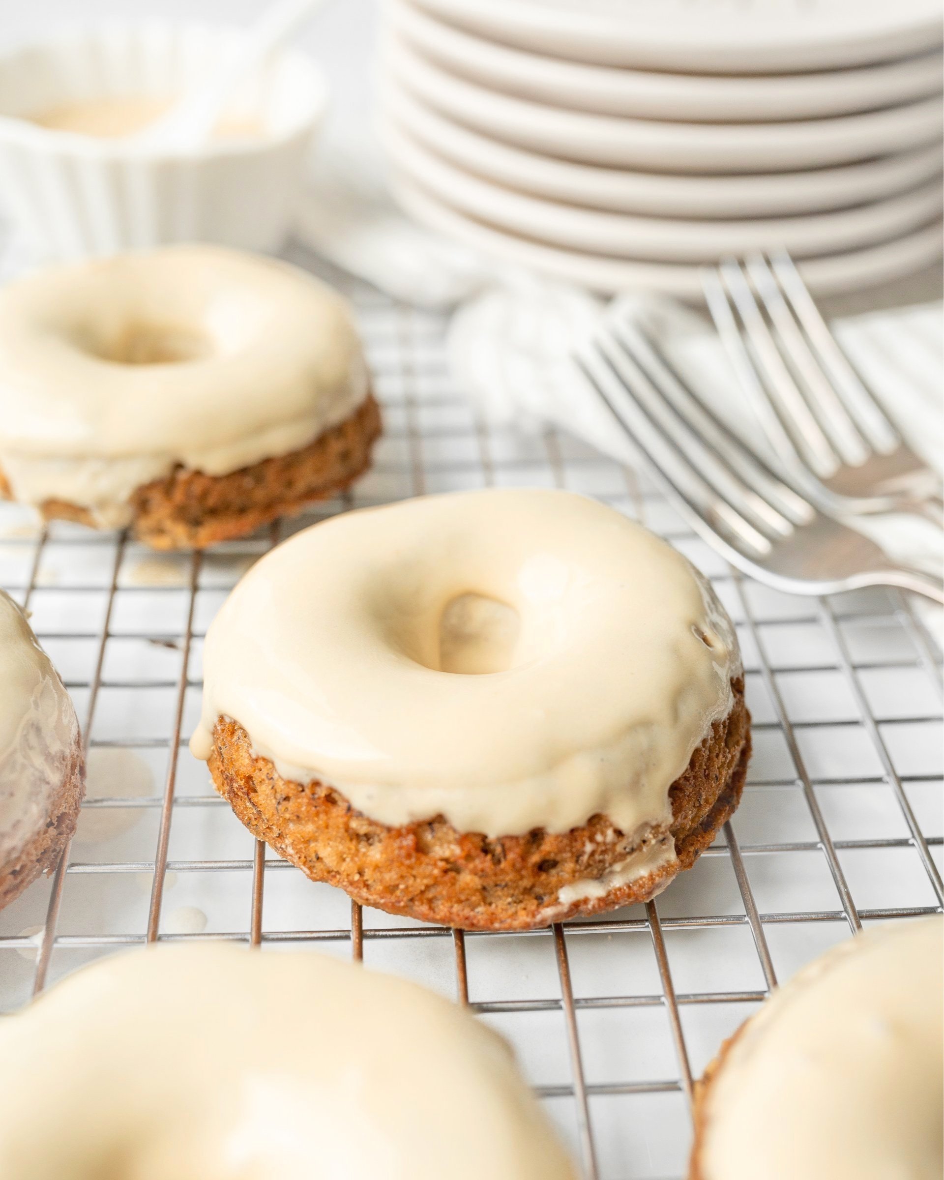 Gluten Free Banana Bread Donuts glazed and set on a wire cooling rack.