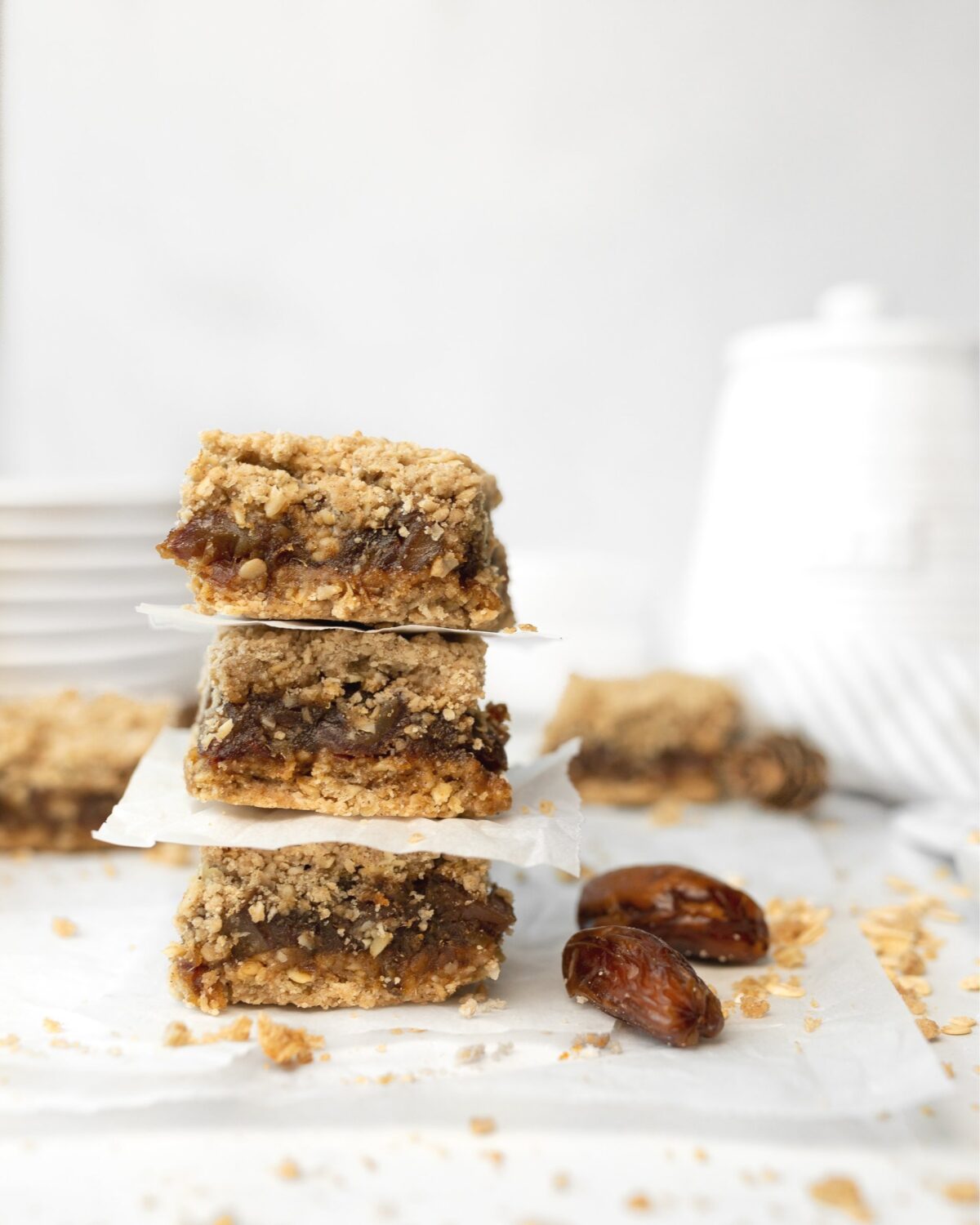 3 Gluten Free Chewy Date Bars stacked on top of each other on parchment. 