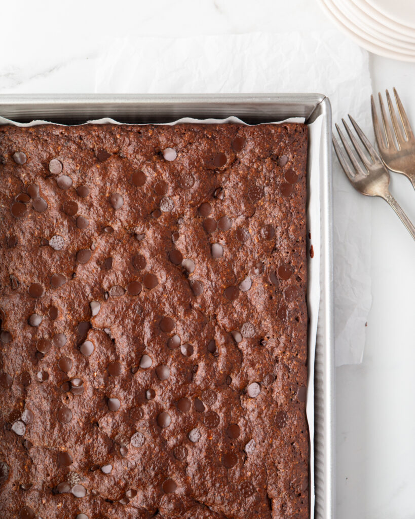 Chocolate Banana Protein Snack Cake baked in a parchment-lined pan. 