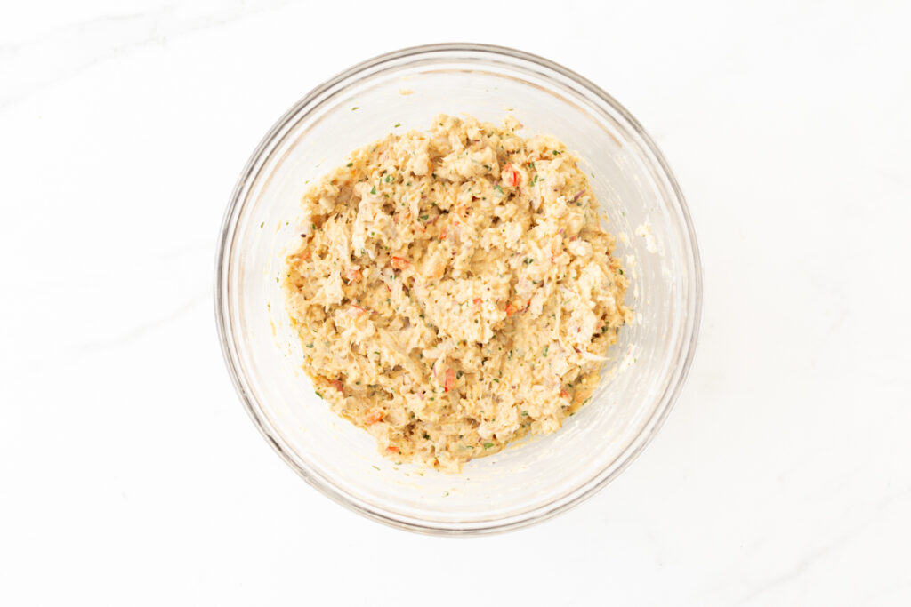 Process shot #3: All ingredients for the cod cakes prepared and combined in a glass mixing bowl. 