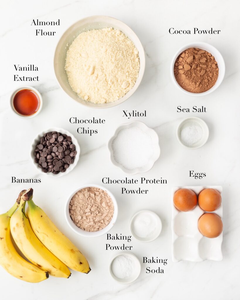 Ingredients for Chocolate Banana Protein Muffins portioned out on a marble slab.
