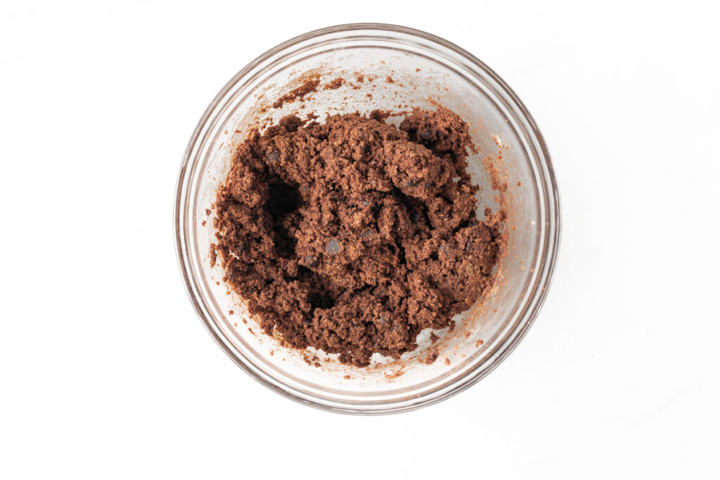 Process shot #3: A glass mixing bowl with all of the ingredients for Double Chocolate cookies combined. Ready to be baked!