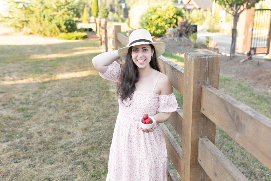 Courtney, CEO of Strawberry Cream Kitchen holding a small bwol of strawberries.