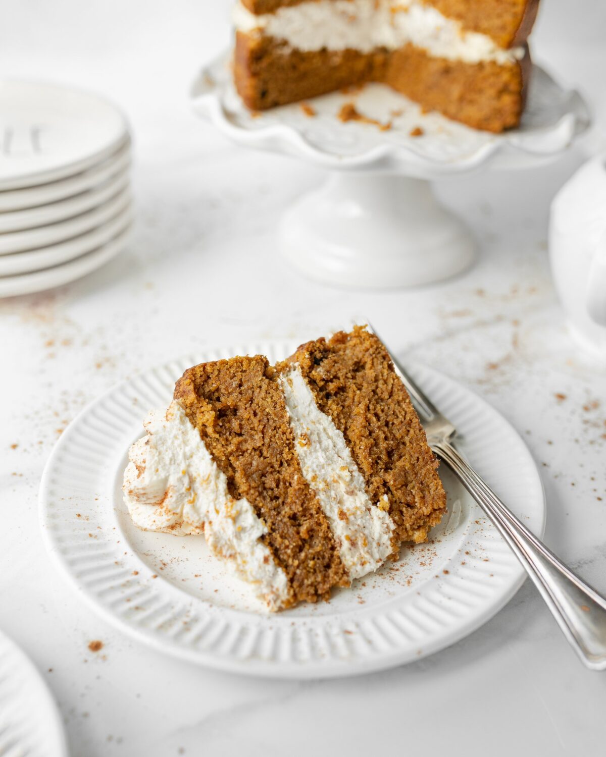 A big slice of Gluten Free Pumpkin Spice Cake with Cream Cheese Frosting plated with a fork.