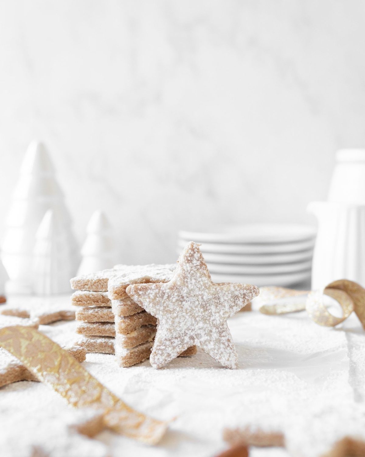 Zimtsterne: Cinnamon Star Cookies stacked on top of each other on parchment paper.