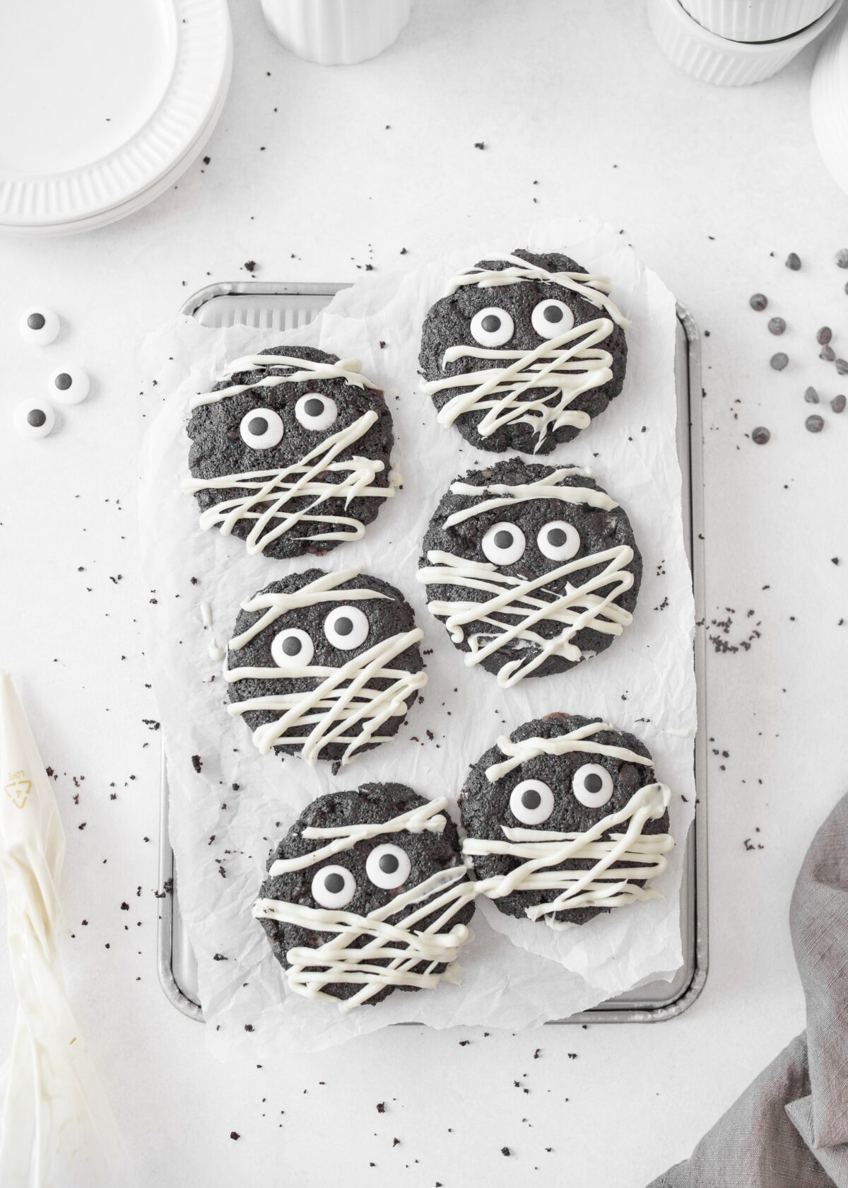 Gluten Free Triple Chocolate Mummy Cookies decorated on parchment paper.