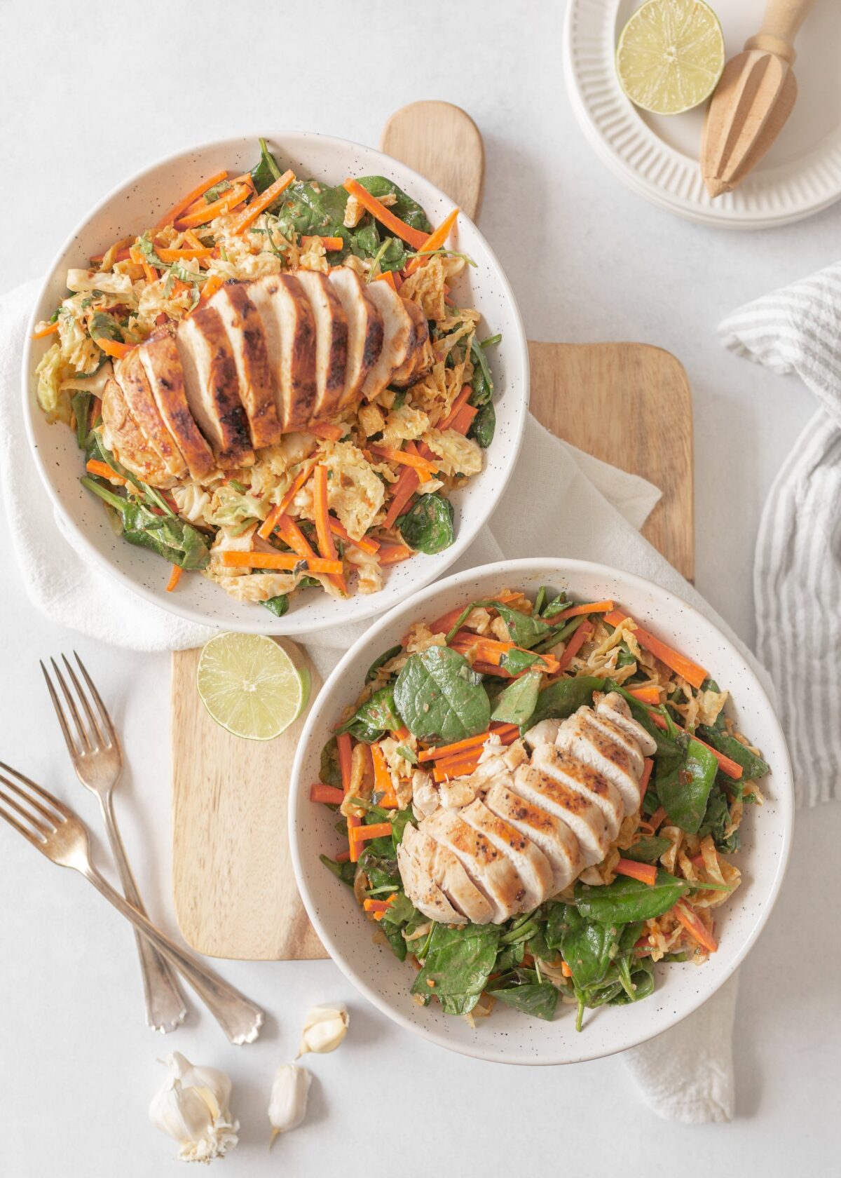 Two Big Thai Chicken Salads served in salad bowls with sliced chicken breast on top.