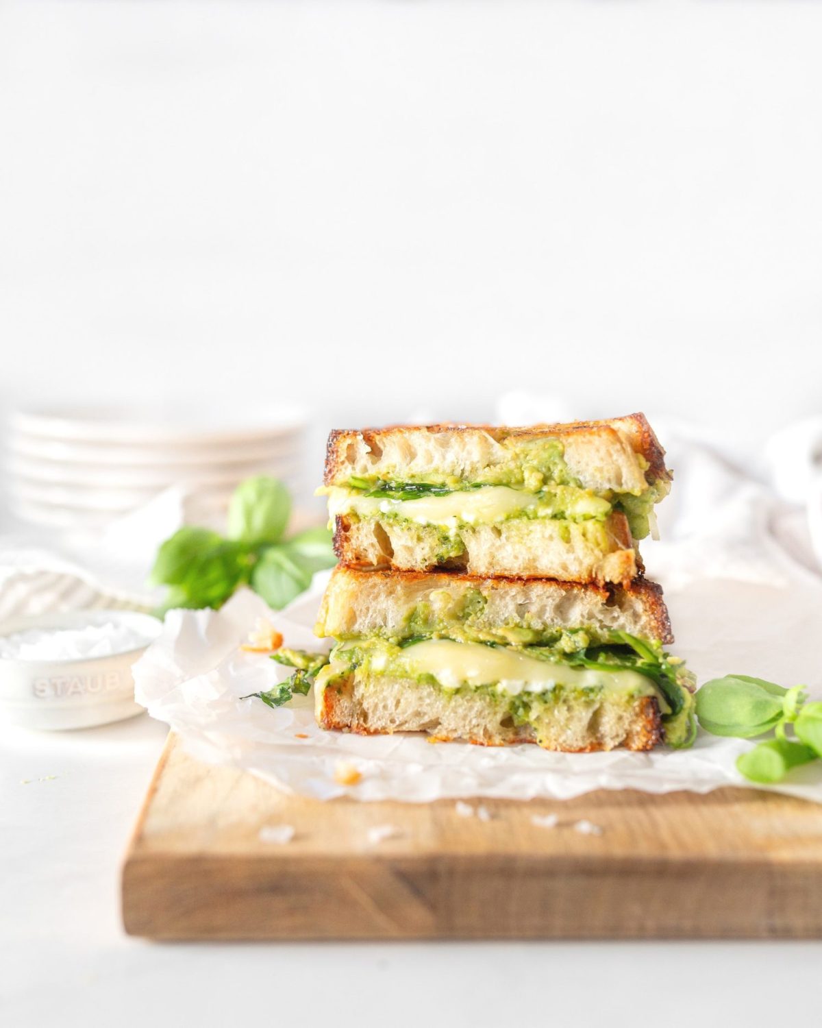 Grilled Pesto Avocado and Feta Sandwich stacked on a cutting board.