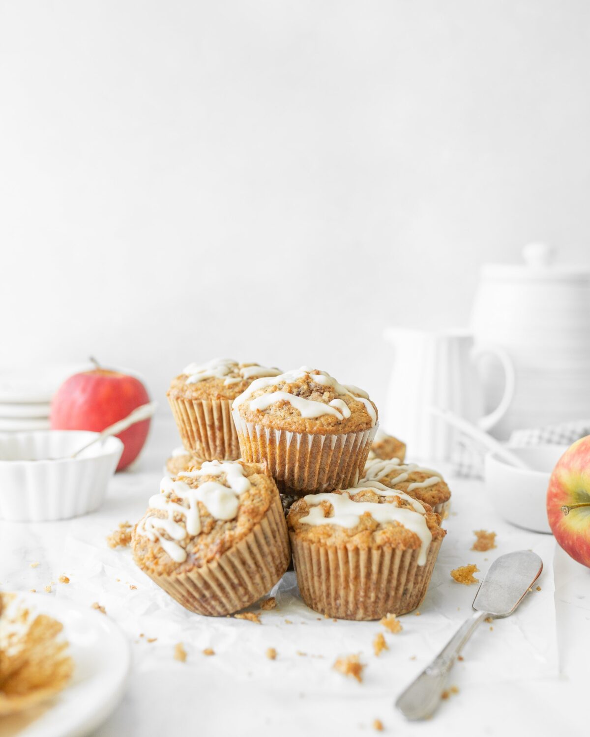Gluten Free Apple Cinnamon Roll Muffins piled up on parchment paper.