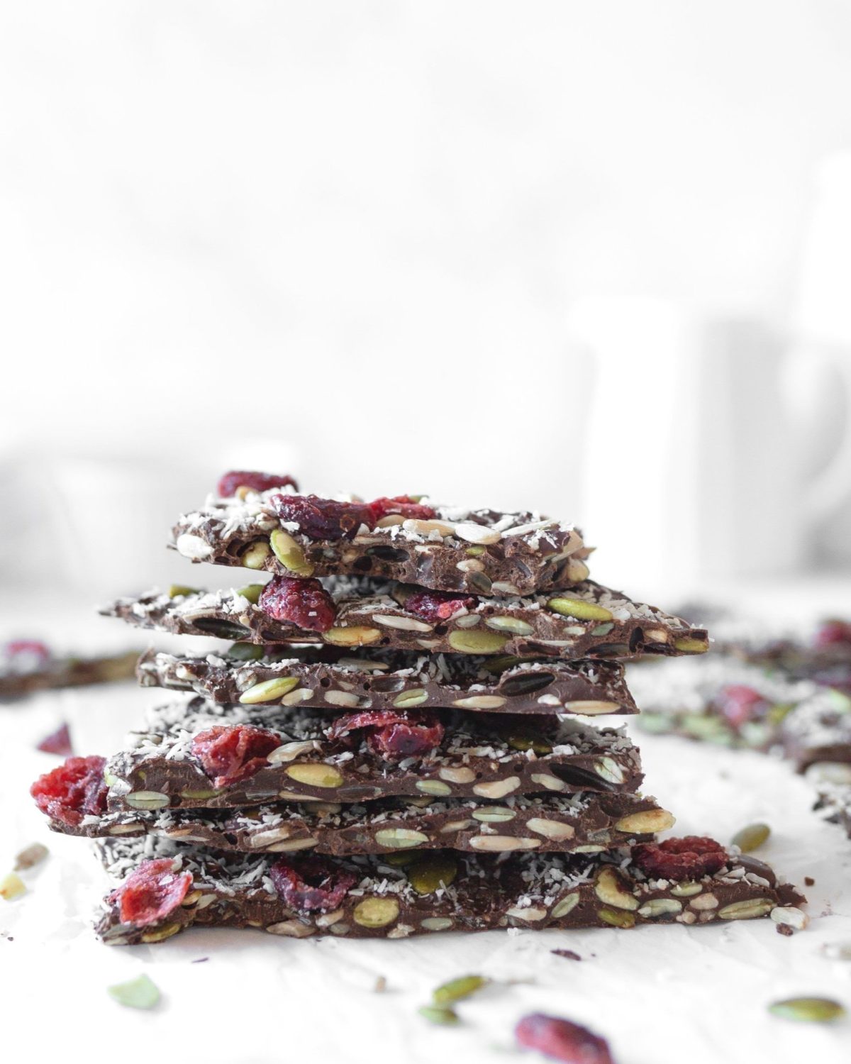 Chocolate Seed Bark with Cranberries stacked on parchment paper.