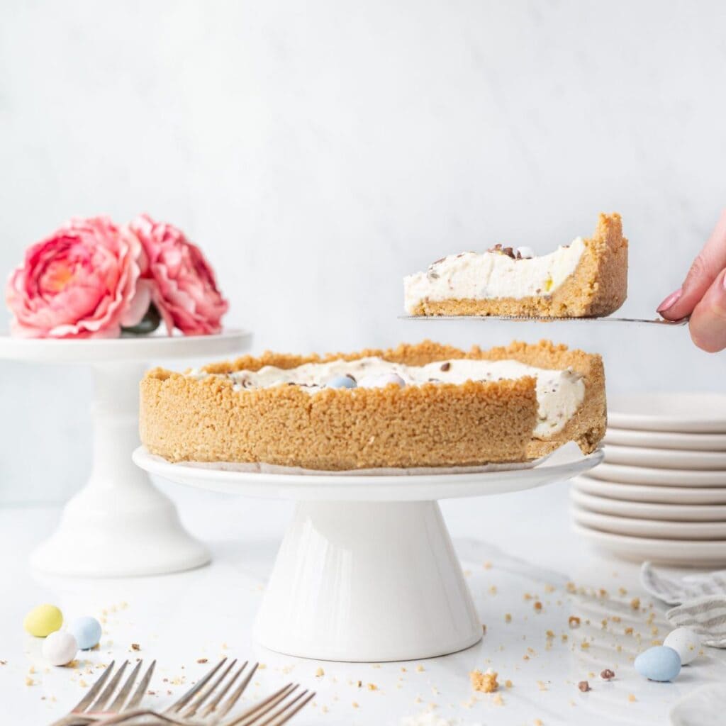 GF No Bake Mini Egg Cheesecake displayed on a cake stand.