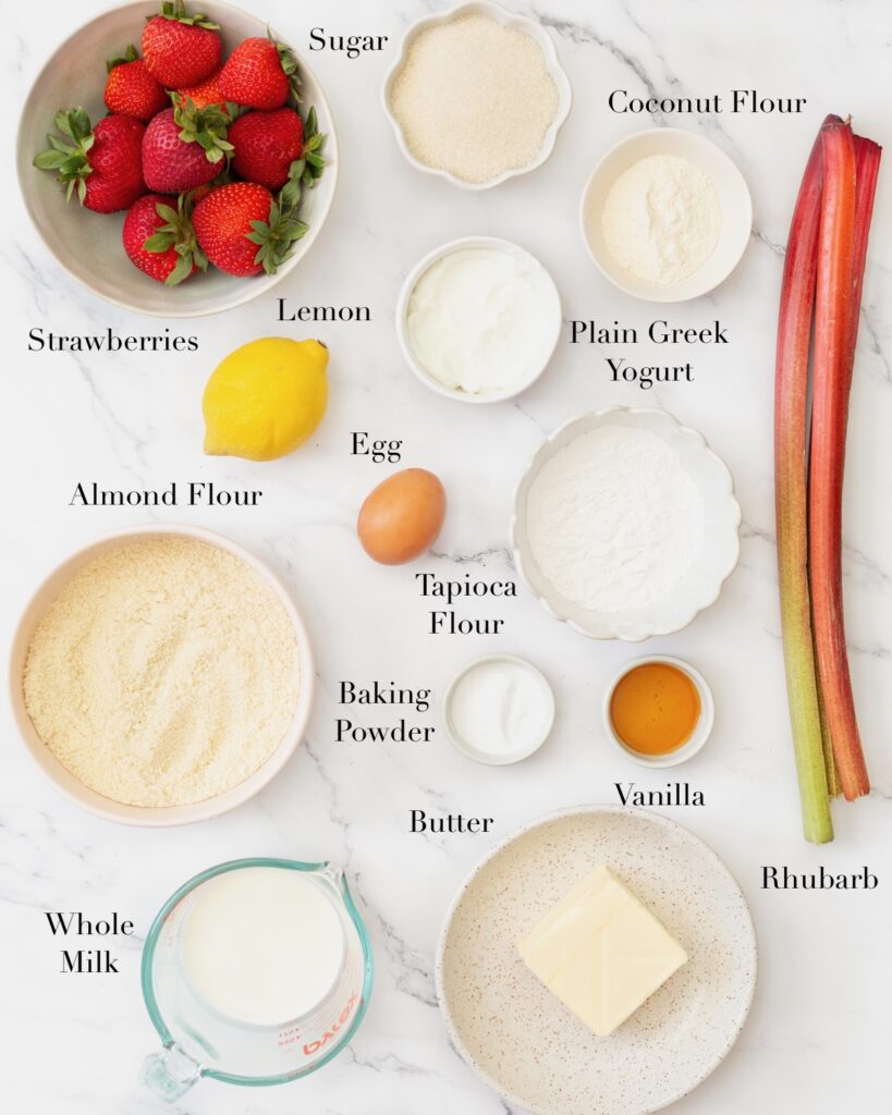 Ingredients for Gluten Free Strawberry Rhubarb Cake portioned out on a marble slab.