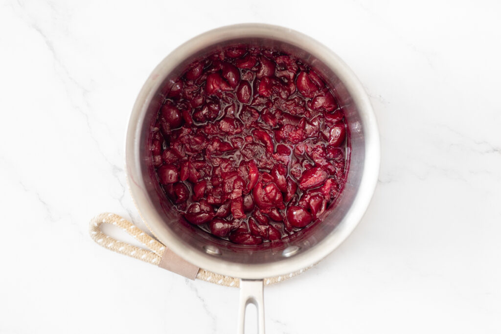 Process shot #1: Cherry compote cooked in a small saucepan.