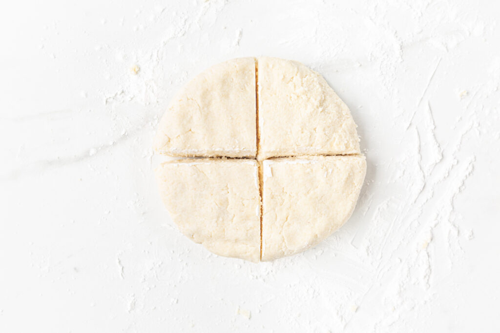 Process shot #3: Almond Flour Greek Yogurt Bagels dough shaped into a disc and then portioned into 4 equal pizza-shaped parts.