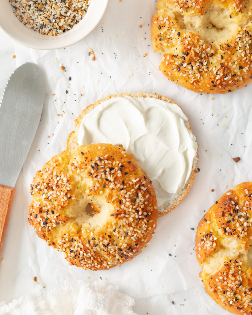 Almond Flour Greek Yogurt Bagels cut in half and slathered with cream cheese.