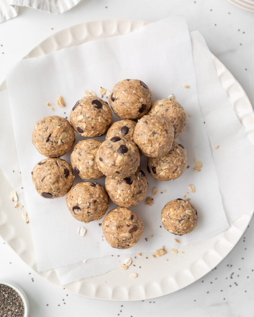 Chocolate Almond Butter Protein Bites piled on a parchment-lined dinner plate.