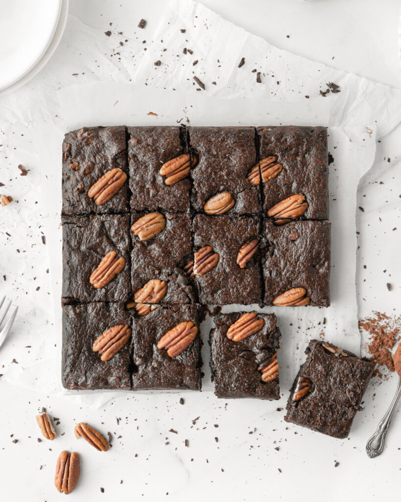 Triple Chocolate Pecan Collagen Brownies baked and cut on parchment paper.