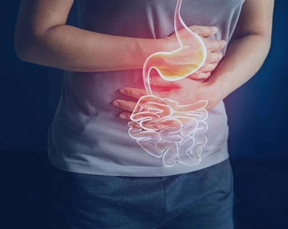 Person holding stomach with digital stomach overlay for indigestion relief.
