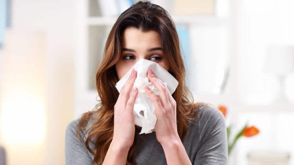 Woman sneezing into tissue, health and treatment concept.