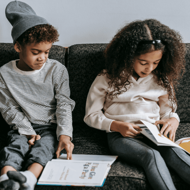 Two black children reading books