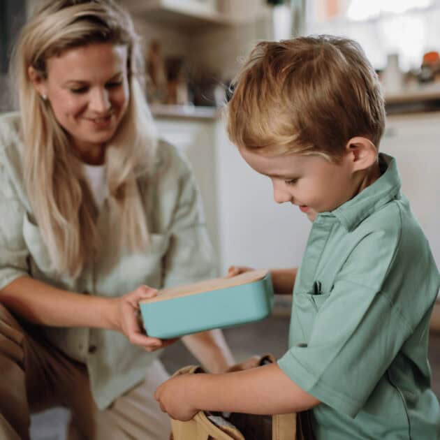 A kid putting his healthy packaged vegan snacks in his lunch box