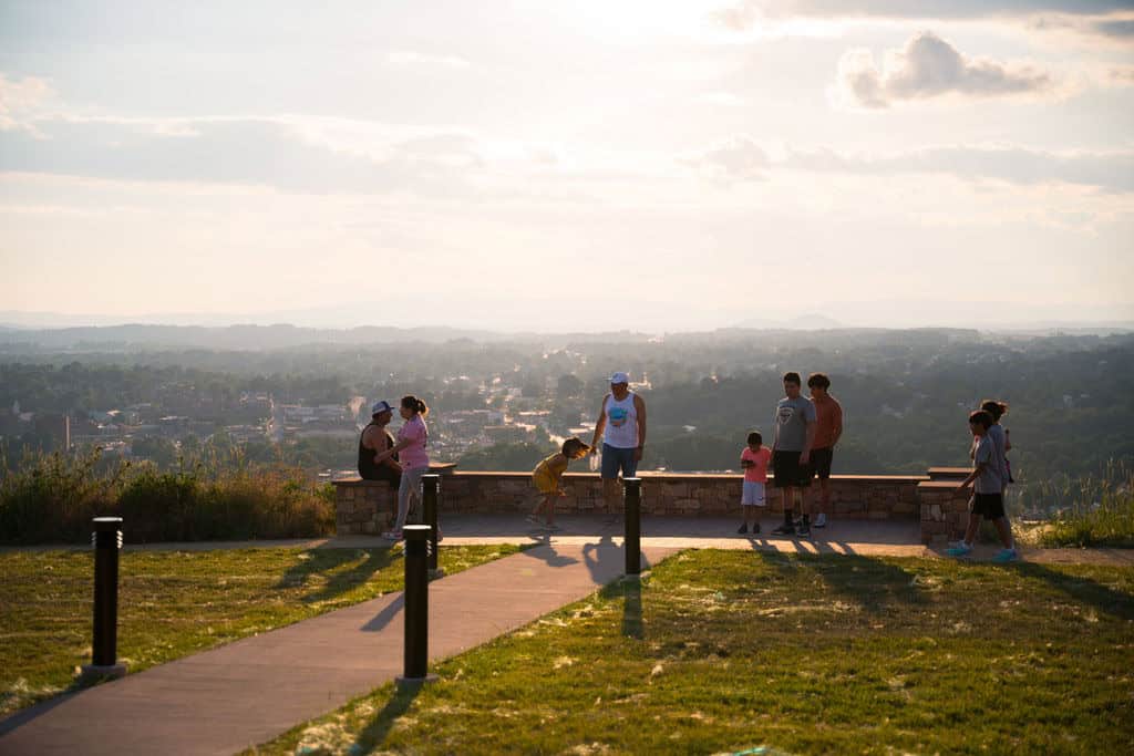 People gathered at the Sunset Park overlook at sunset, with the valley and town of Waynesboro below
