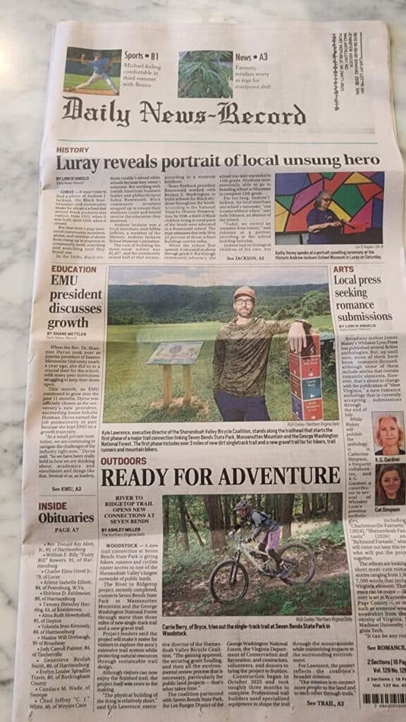 Front page of the Daily News-Record with the headline "Ready for Adventure," featuring a photo of Kyle Lawrence beside a trail sign at Seven Bends State Park and a mountain biker riding the new singletrack.