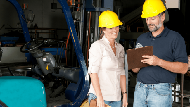man and women beside forklift safety checklist