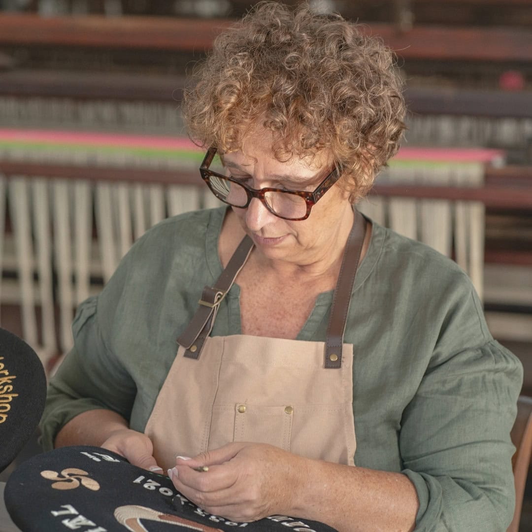 Valeria revisando una txapela personalizada en el taller de Teletxapela