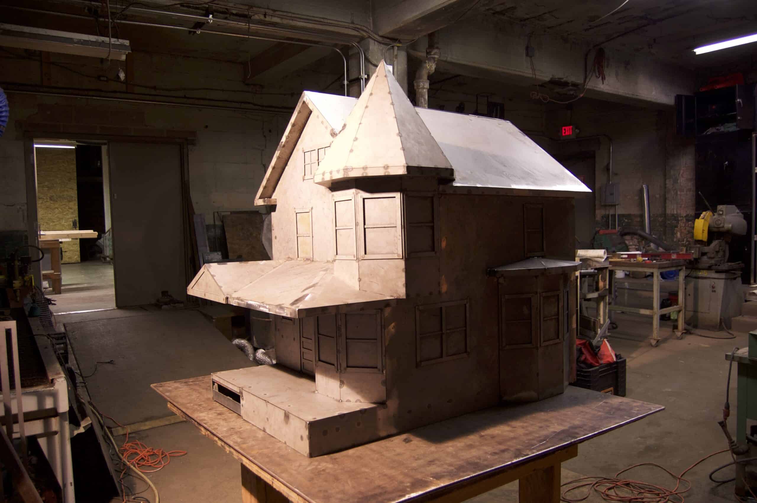 Wooden house model with turret for architectural design or miniature display.