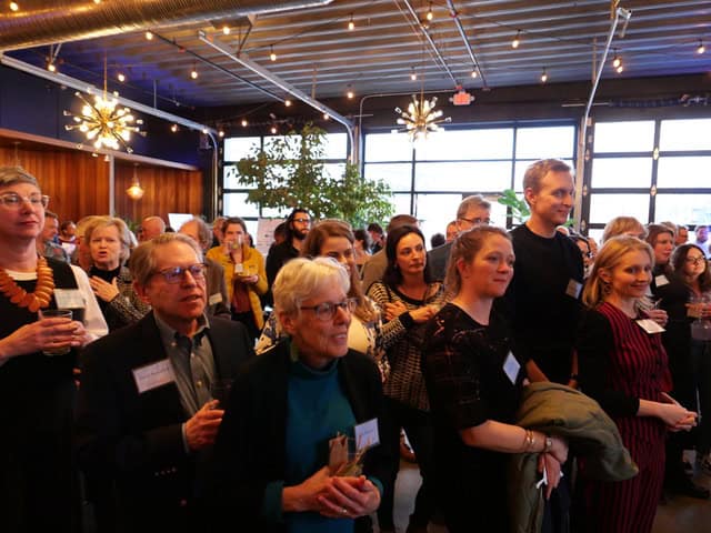 People attending an art exhibition at TEMPOart gallery, engaging with artwork and enjoying the vibra.