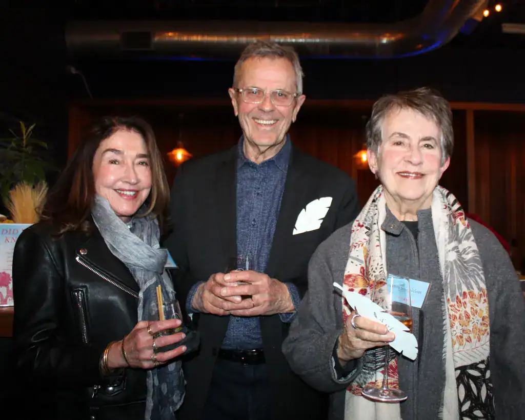 Public art celebration with smiling attendees holding drinks at an event.